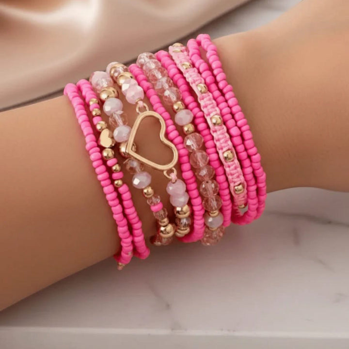 Chic Collective pink beaded bracelet stack with gold heart charm and crystal accents.